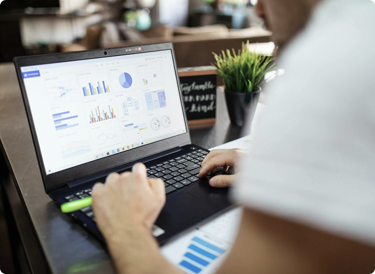 Person working on a laptop displaying charts and graphs.