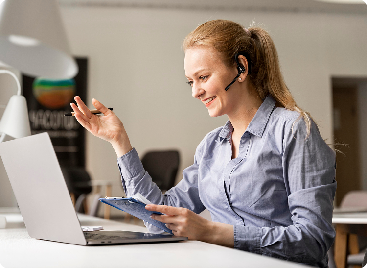 Woman wearing a headset smiling during a video call on her laptop.